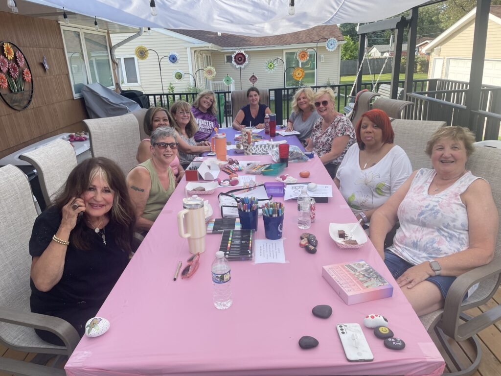Munster Junior Woman's Club members gathered around a table painting rocks for local parks and coloring Cards of Hope for Phil's Friends.